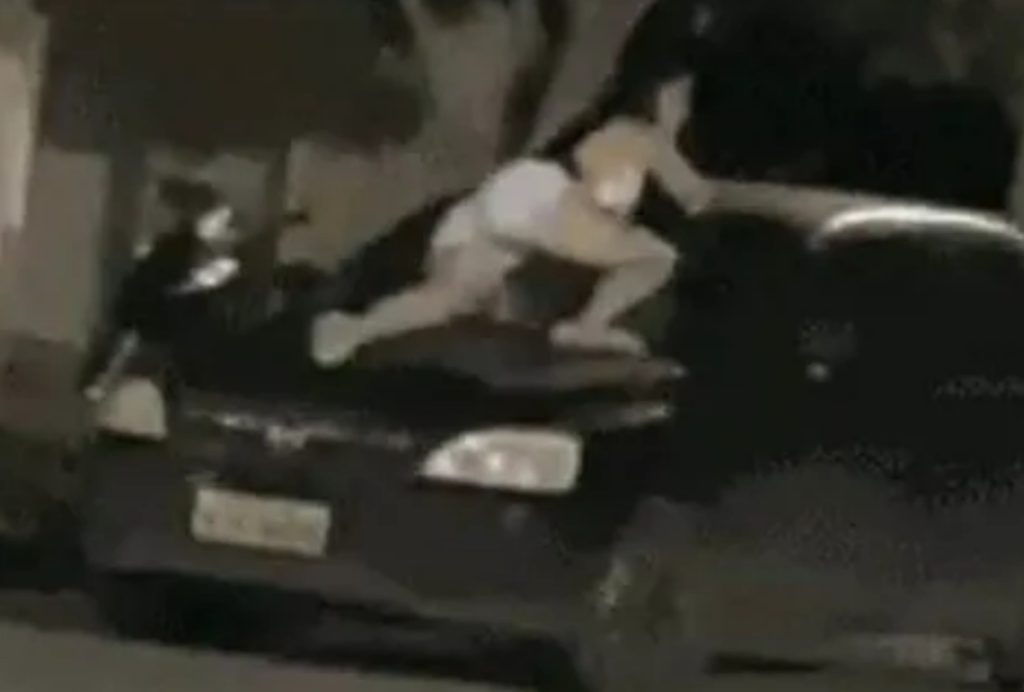 mulher se joga no carro do marido