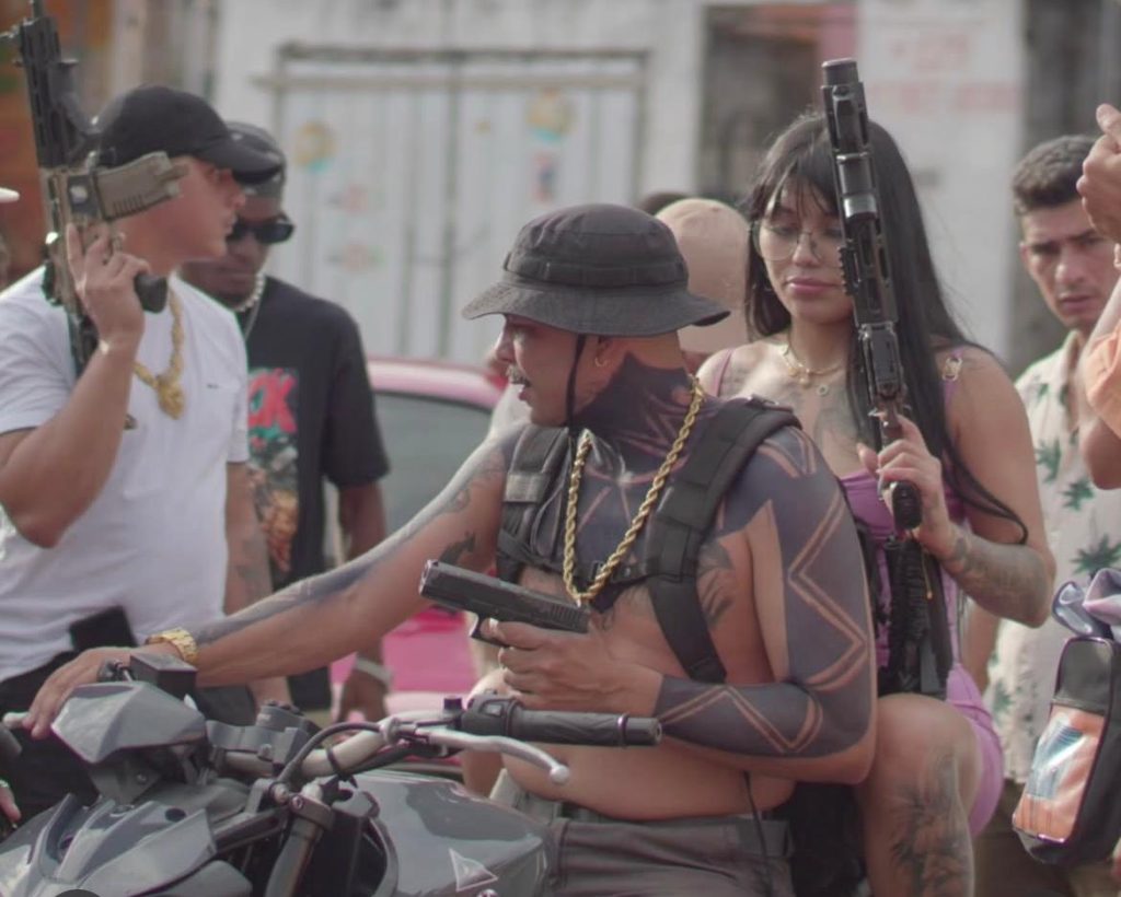 jovem em clipe musical ostentando armas
