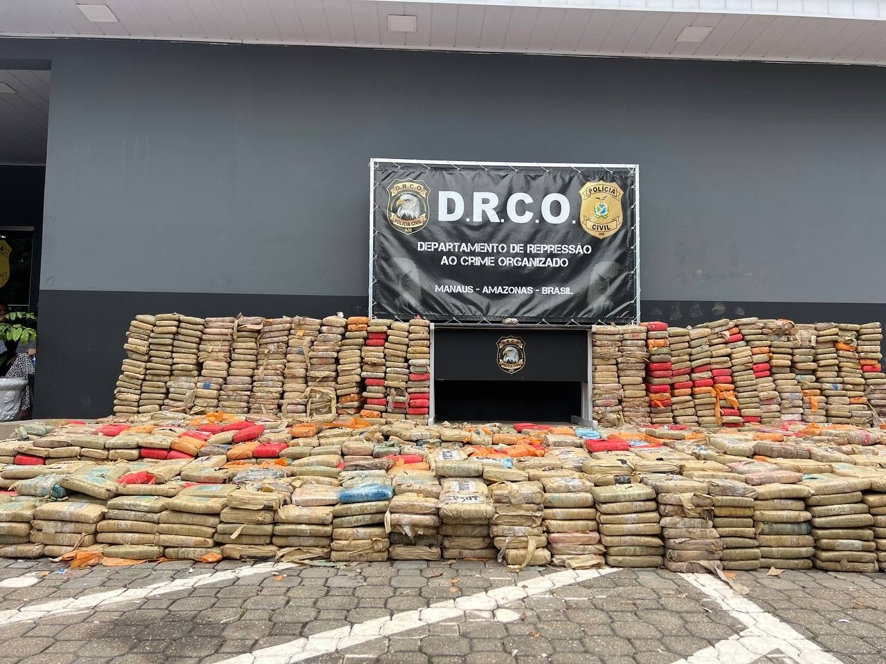 Policiais exibem grande quantidade de drogas apreendidas durante operação no bairro Tarumã em Manaus.