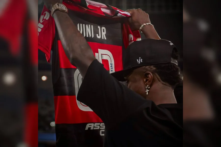 Vini Jr. marca golaço no Real Madrid contra Benfica e denuncia racismo de Prestianni, que teria dito "macaco" cinco vezes segundo Mbappé. Flamengo, formador do craque, posta apoio emocionante: "Racismo não é parte do jogo". Buscas por "Vini Jr racismo Champions" explodem – vídeos e protocolos UEFA impulsionam engajamento em debates globais de futebol.