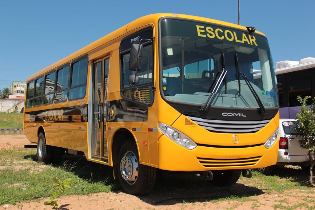 Estudantes em frente a um ônibus escolar em Guajará aguardando transporte para universidade no Acre