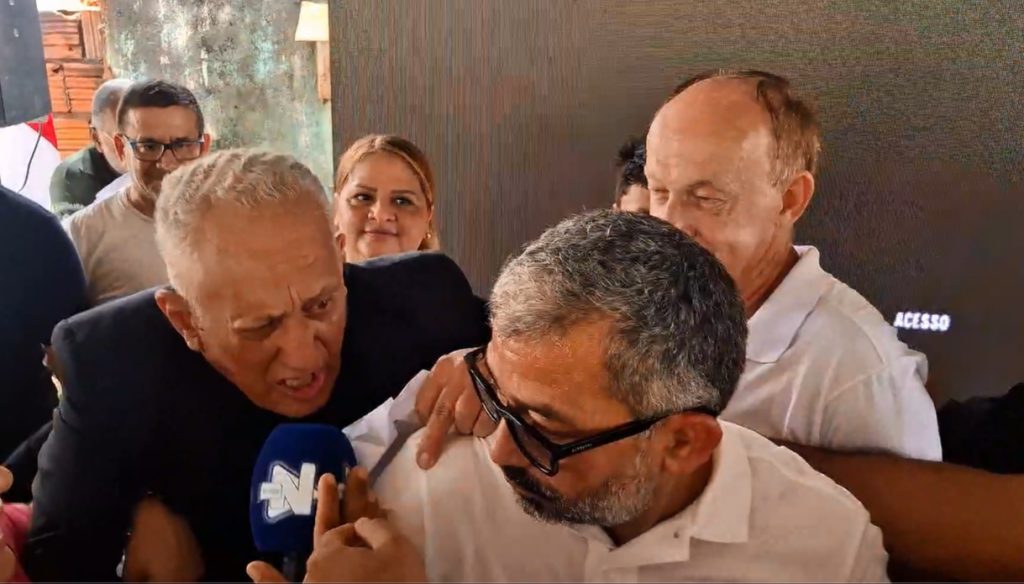 Repórter Wanderlei Modesto tentando entrevistar o prefeito de Iranduba Augusto Ferraz cercado por seguranças