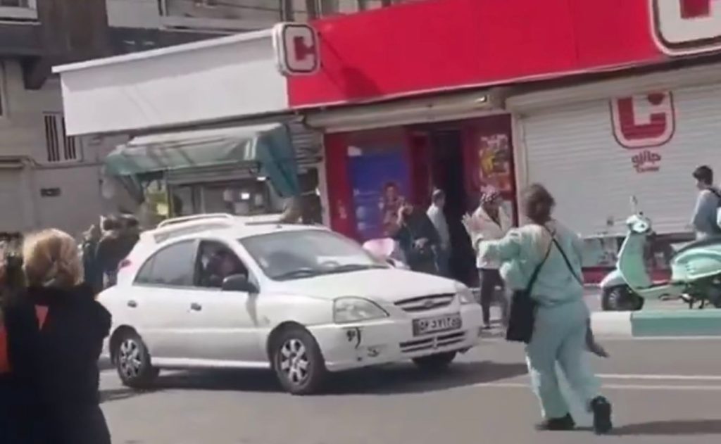 Mulheres iranianas em espaço público retirando o véu islâmico em sinal de protesto e comemoração após ataques militares.