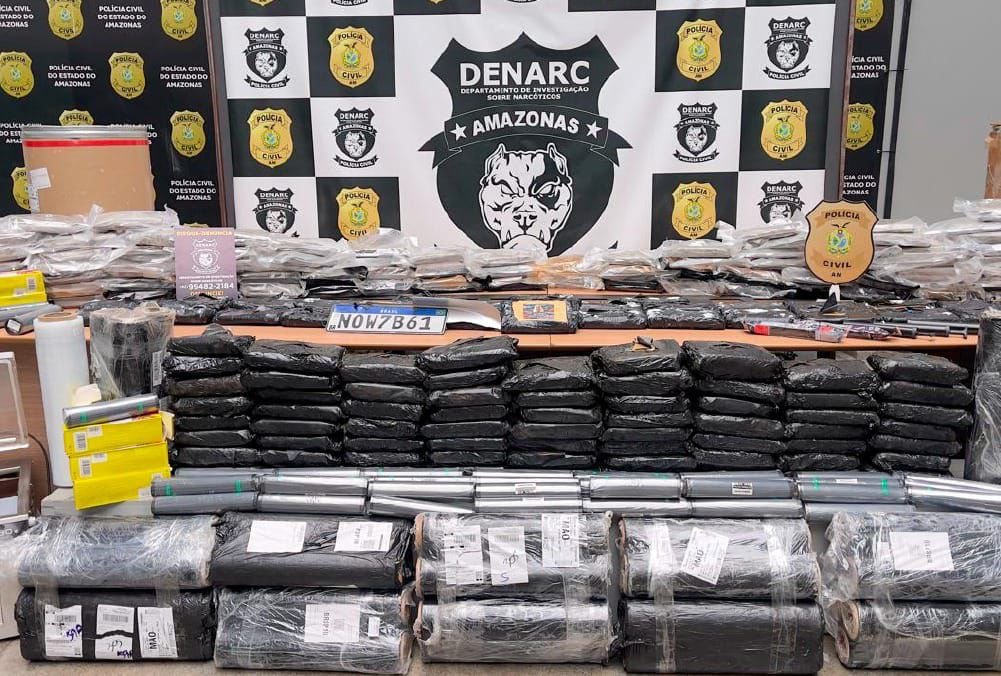 Policiais do Amazonas exibem grandes quantidades de drogas apreendidas durante operação contra o tráfico de drogas no estado.