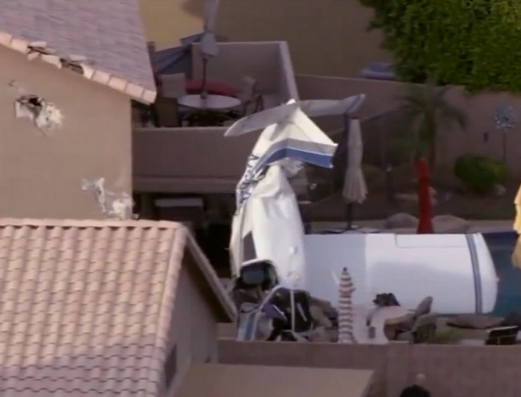 Avião de pequeno porte caído em quintal de residência após colisão contra casas em Phoenix no Arizona.
