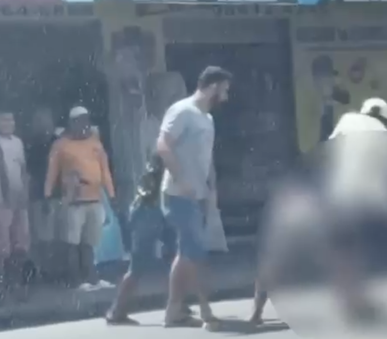 Homem sendo detido por populares após tentativa de assalto em uma drogaria de Manaus.