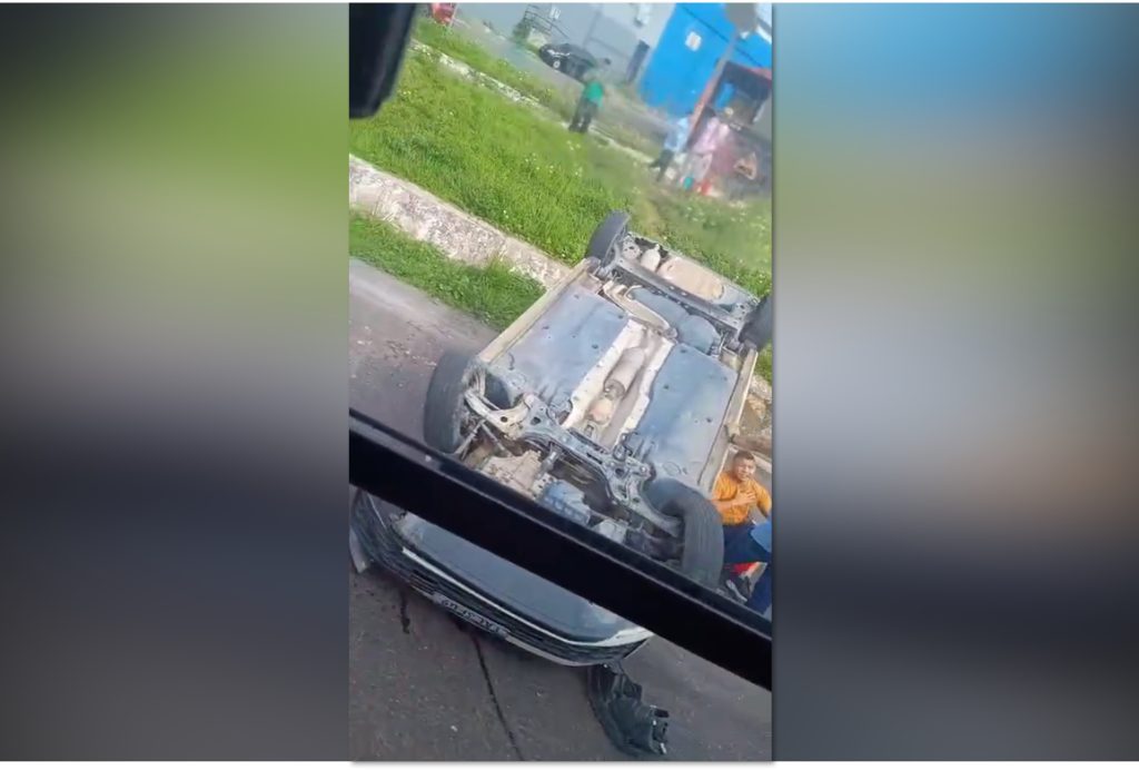 Carro de passeio capotado na Avenida Presidente Dutra em Manaus com pessoas ao redor prestando socorro