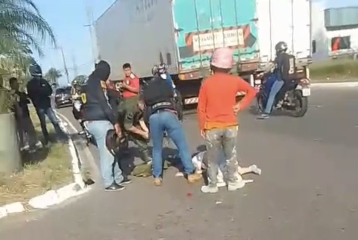 Vítimas de acidente entre moto e carreta recebendo atendimento médico no asfalto da avenida Ministro Mário Andreazza em Manaus