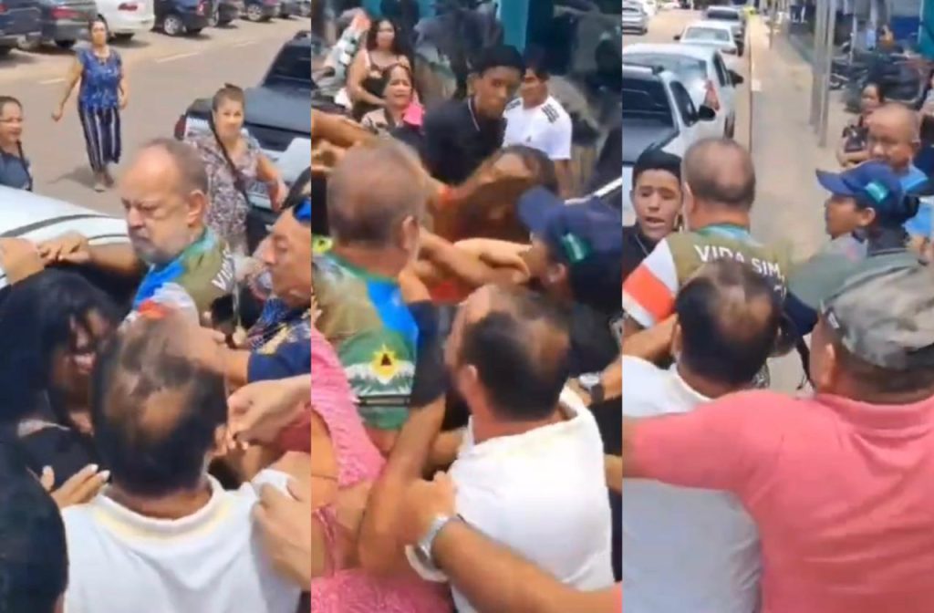 Manifestantes e guardas municipais em confronto na frente da Câmara Municipal de Iranduba durante votação polêmica.