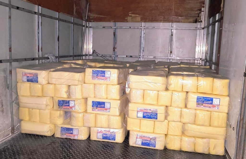 Agentes da Vigilância Sanitária de Manaus fiscalizando e apreendendo grandes blocos de queijo muçarela vencido em comércio.