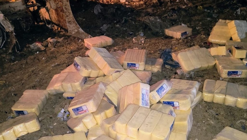 Agentes da Vigilância Sanitária de Manaus fiscalizando e apreendendo grandes blocos de queijo muçarela vencido em comércio.