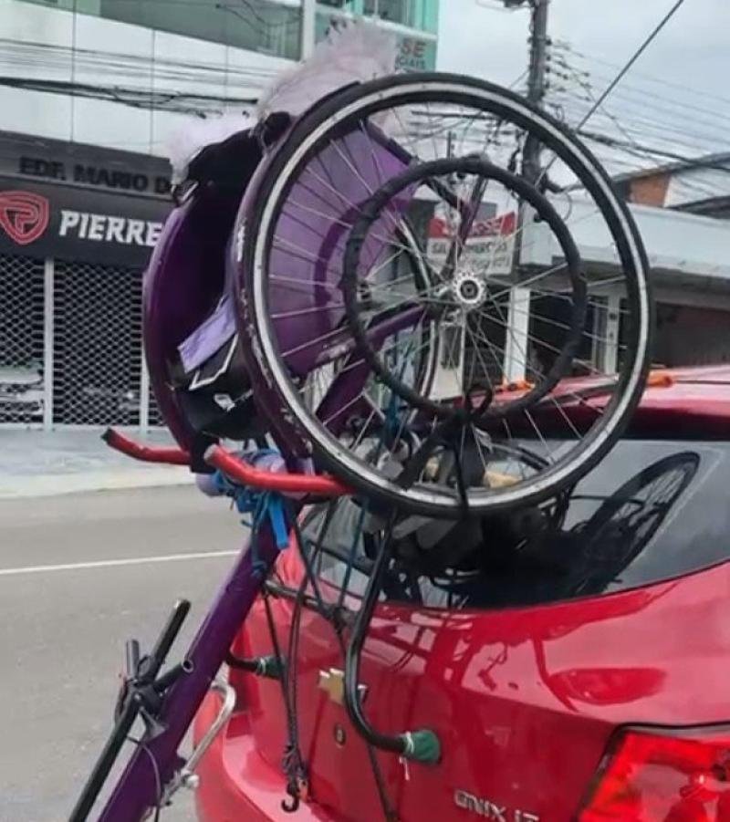 Veículo parado em via urbana de Manaus após acidente envolvendo participante de corrida de rua em cadeira de rodas durante a manhã.