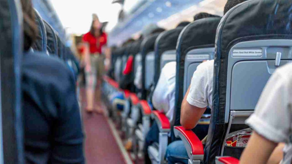 Passageiro em aeroporto buscando informações sobre direitos e indenização por rebaixamento de classe em voo