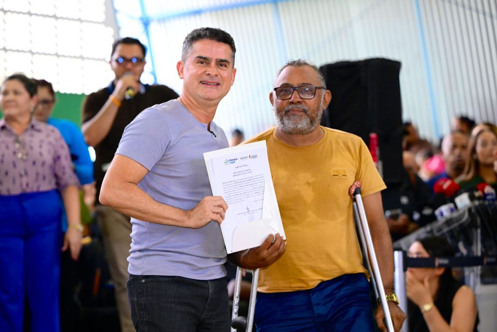 Prefeito David Almeida durante solenidade de entrega de títulos definitivos de imóveis para famílias de Manaus.