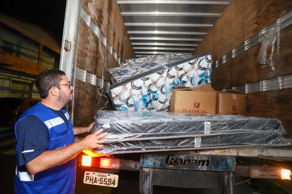 Equipes da prefeitura de Manaus distribuindo suprimentos e colchões para moradores atingidos por forte chuva em Manaus.