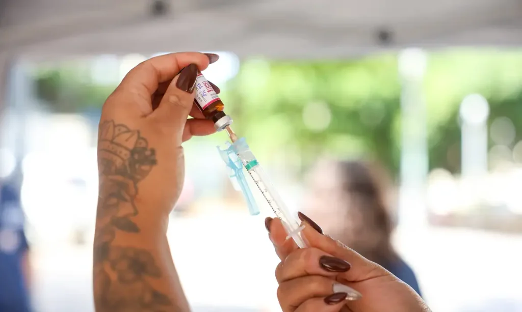 Profissional de saúde aplicando vacina para prevenção de doenças como o sarampo.