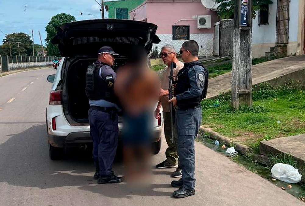 Policial civil conduz homem algemado para viatura apos prisao por roubo a drogaria em Maues
