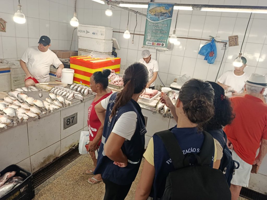 Fiscais da Vigilância Sanitária de Manaus inspecionando a qualidade e higiene do pescado em feira local durante a Operação Semana Santa