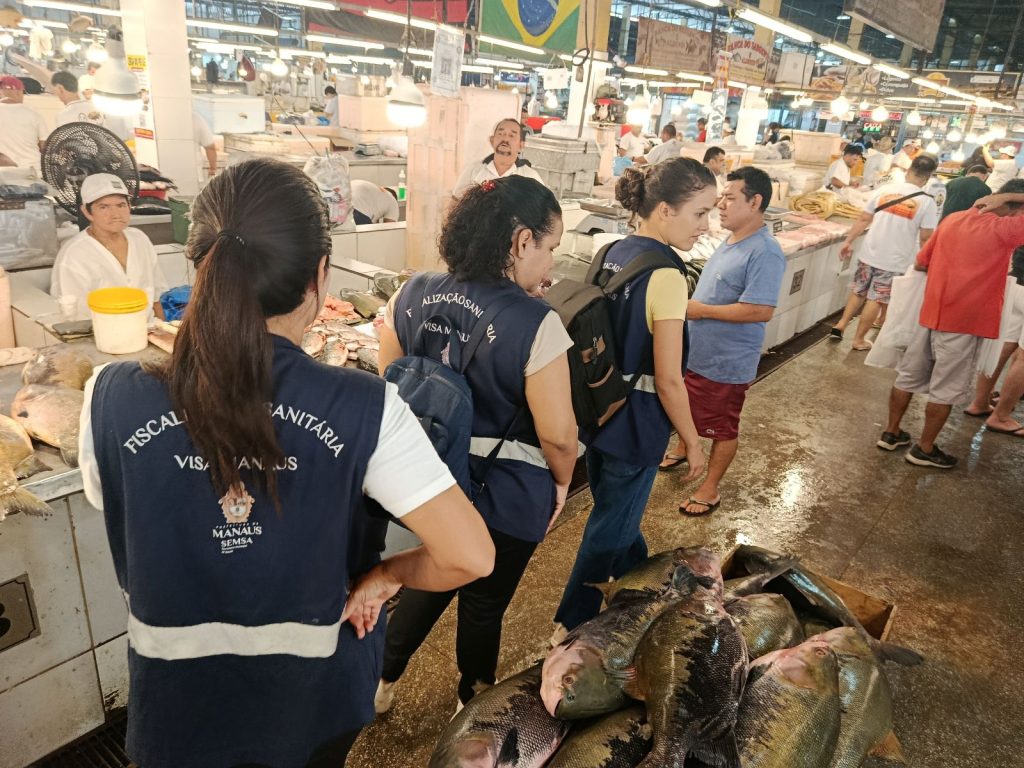 Fiscais da Vigilância Sanitária de Manaus inspecionando a qualidade e higiene do pescado em feira local durante a Operação Semana Santa