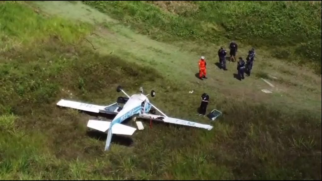 Destroços de aeronave de pequeno porte no Aeroclube de Manaus com equipes de resgate e segurança no local do acidente.