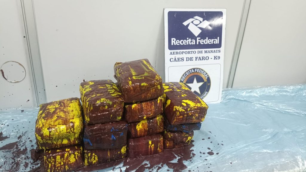 Agentes da Receita Federal inspecionam carga de polpa de açaí contendo tabletes de skunk no Aeroporto Internacional de Manaus.