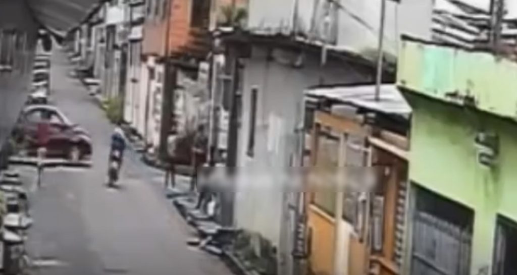 Momento da colisão entre motocicleta e carro no bairro Lírio do Vale 2 em Manaus capturado por câmera de segurança.