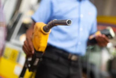 Bombas de combustível em posto de gasolina com destaque para os bicos de abastecimento de gasolina e etanol.