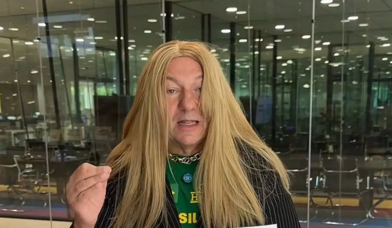 Empresário Luciano Hang usando peruca loira e roupas femininas em vídeo criticando a deputada Erika Hilton.