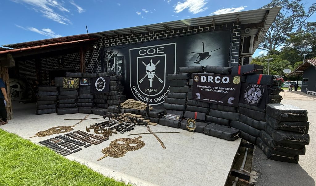 Policiais militares e civis do Amazonas exibem grandes quantidades de drogas e armas apreendidas em operações integradas no estado.