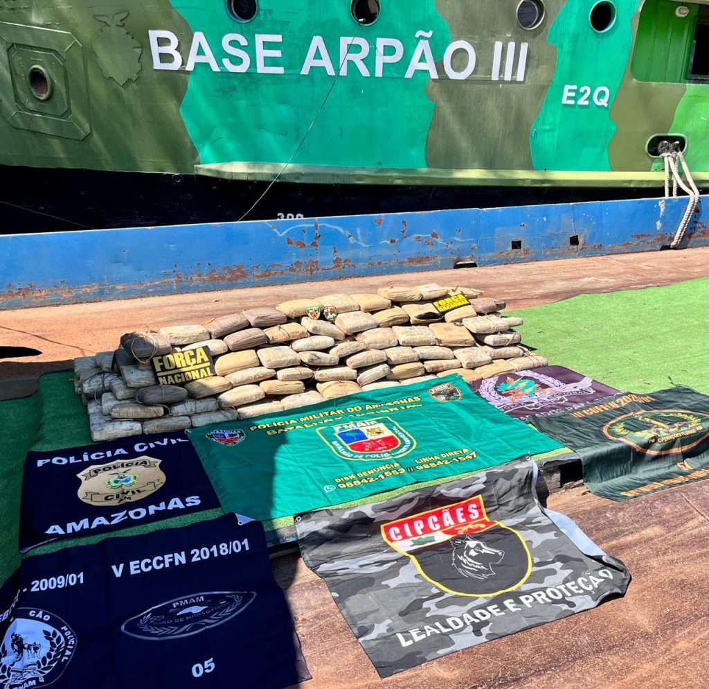 Policiais militares e civis do Amazonas exibem grandes quantidades de drogas e armas apreendidas em operações integradas no estado.