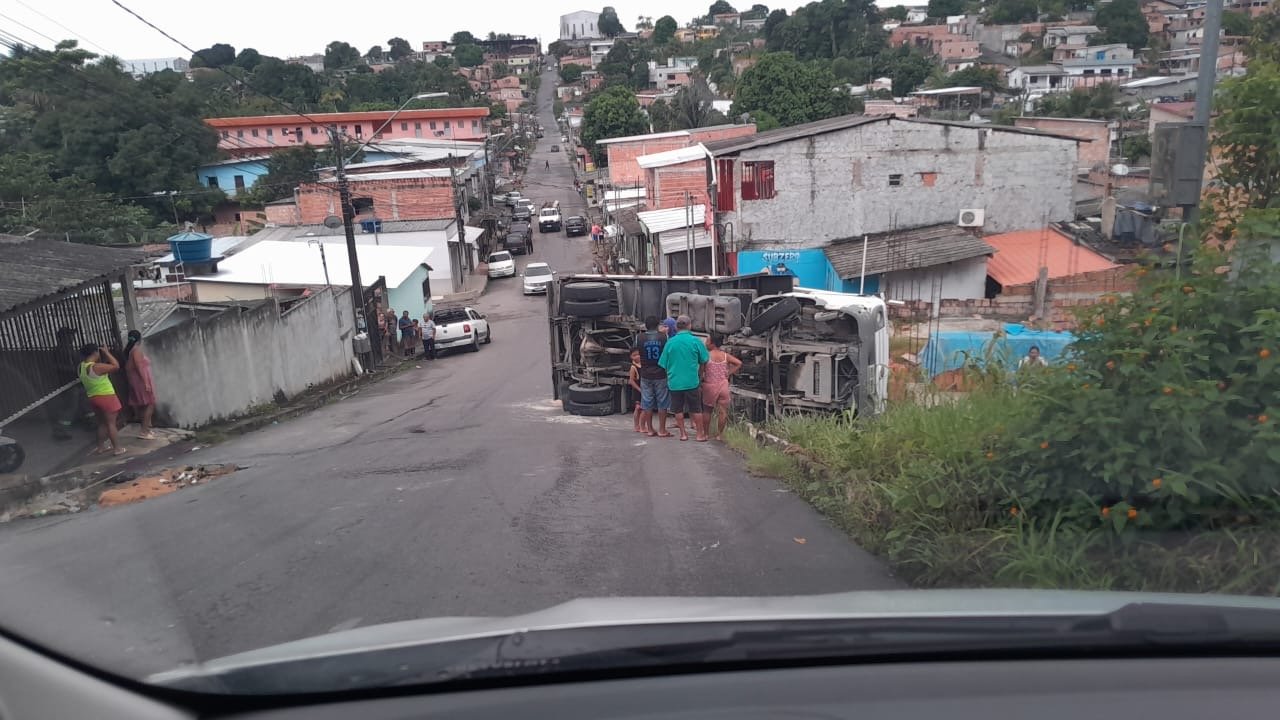 Caminhão carregado com areia tombado na via após motorista desviar de buraco na zona norte de Manaus.