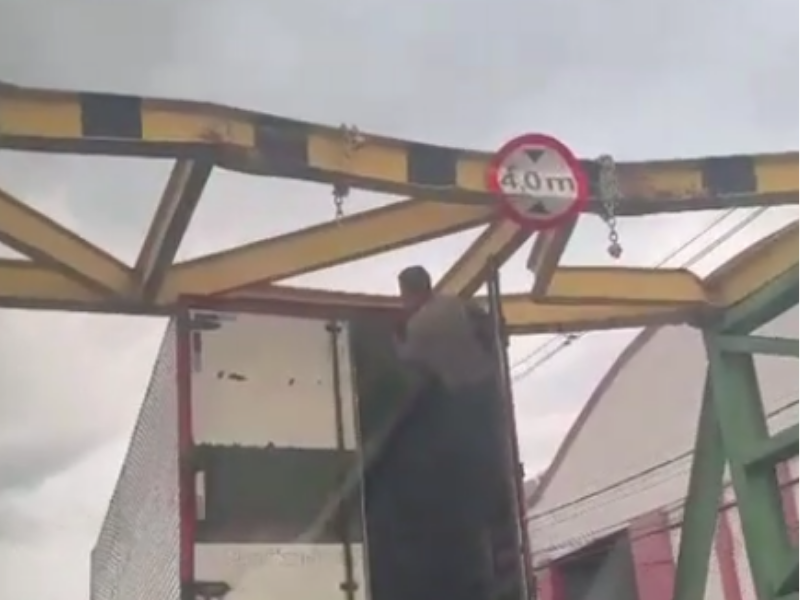Caminhão de carga preso sob a estrutura do limitador de altura na avenida João Valério em Manaus