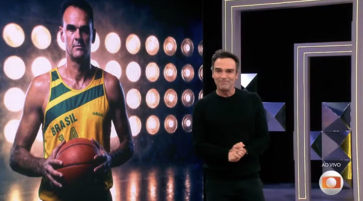 Tadeu Schmidt emocionado durante a apresentação do BBB26 em homenagem ao irmão Oscar Schmidt.
