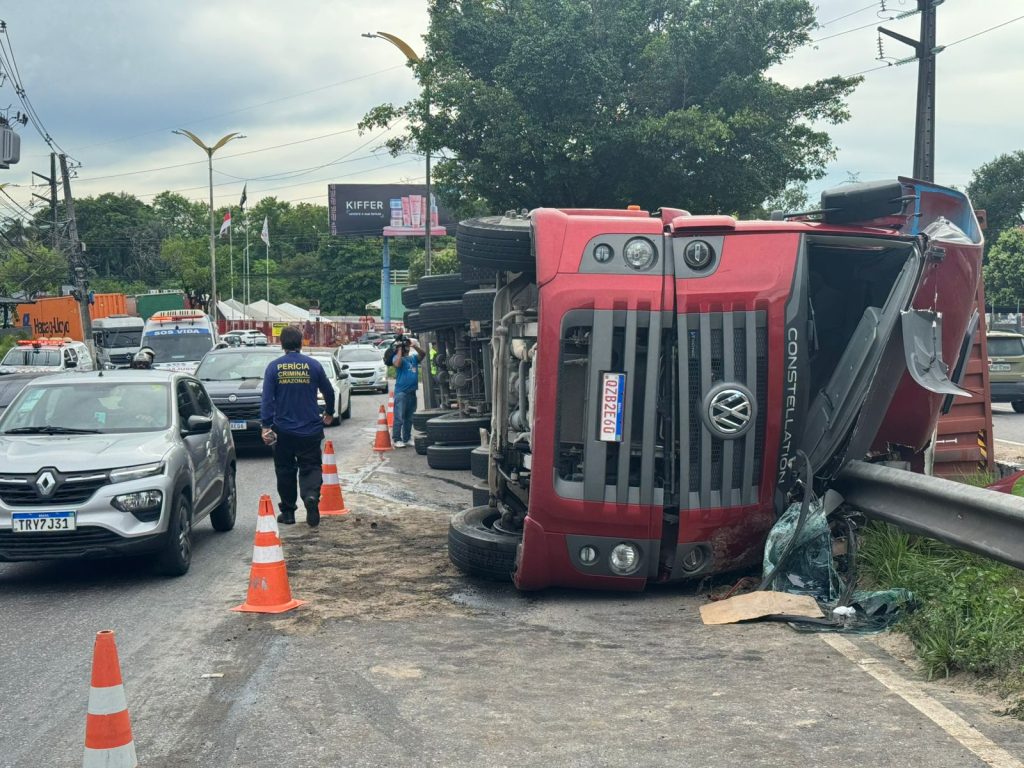 Carreta tombada atravessada na pista da Avenida Cosme Ferreira em Manaus com poste de luz derrubado e trânsito parado