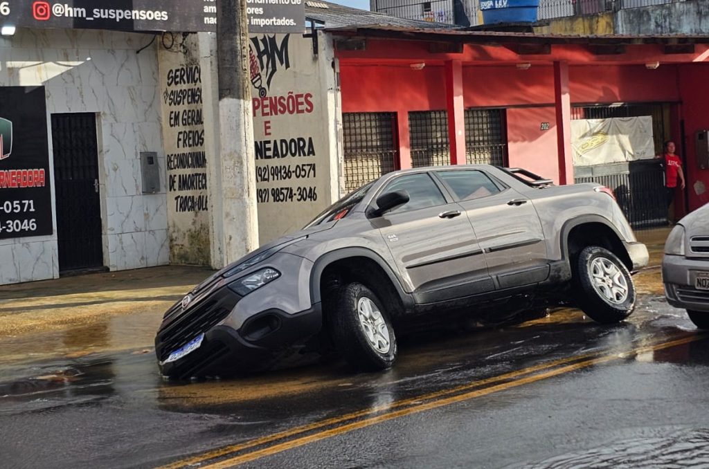 carro caindo em cratera na rua Sávio Belota no bairro Novo Aleixo em Manaus