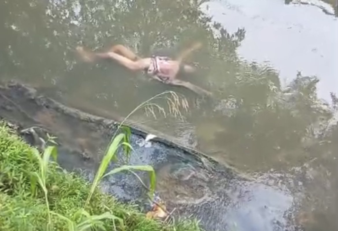 Equipe do corpo de bombeiros realiza o resgate de um corpo preso entre lixo e galhos em um igarapé de manaus