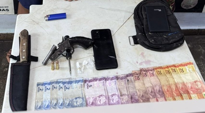 Policiais civis e militares posam ao lado de materiais apreendidos após a prisão de assaltantes de postos em Carauari.