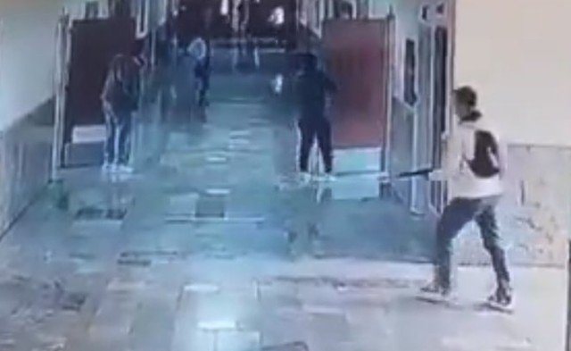 Fachada de escola na Turquia cercada por viaturas policiais e ambulâncias após ataque de ex-aluno.