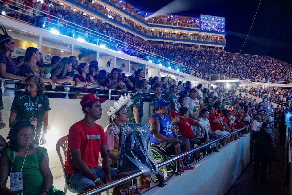 Pessoas acompanhando o Festival de Parintins em área reservada para acessibilidade no Bumbódromo.