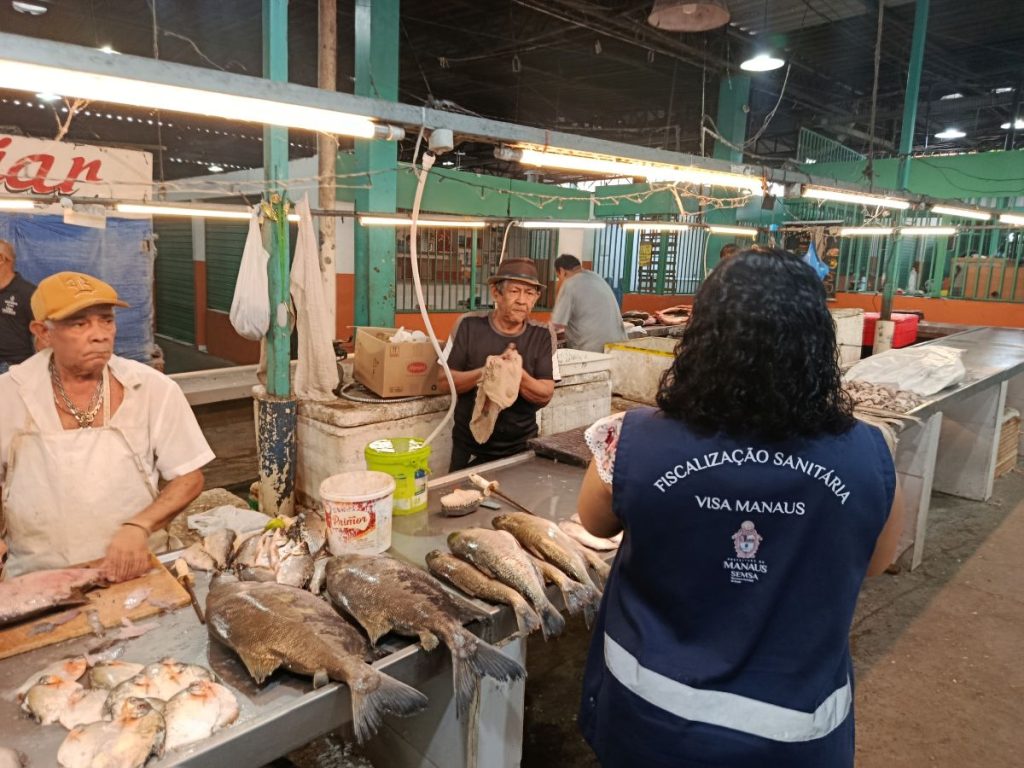Agentes da vigilância sanitária fiscalizam banca de peixes em feira de Manaus
