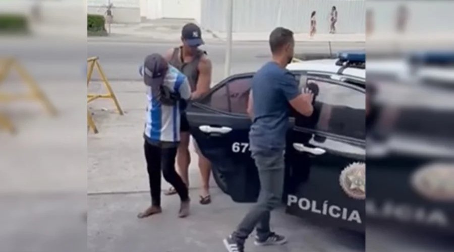 Vendedor ambulante sendo detido por policiais na Praia de Copacabana após aplicar golpe em turista com venda de caipirinha.