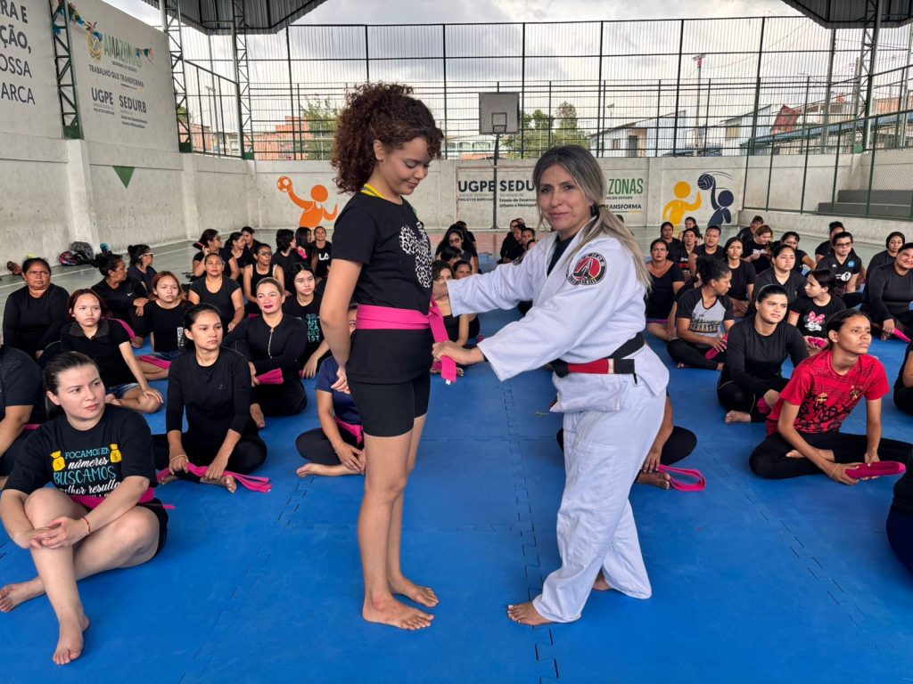 Mulheres participando de treinamento coletivo de técnicas de defesa pessoal e cidadania em Manaus.