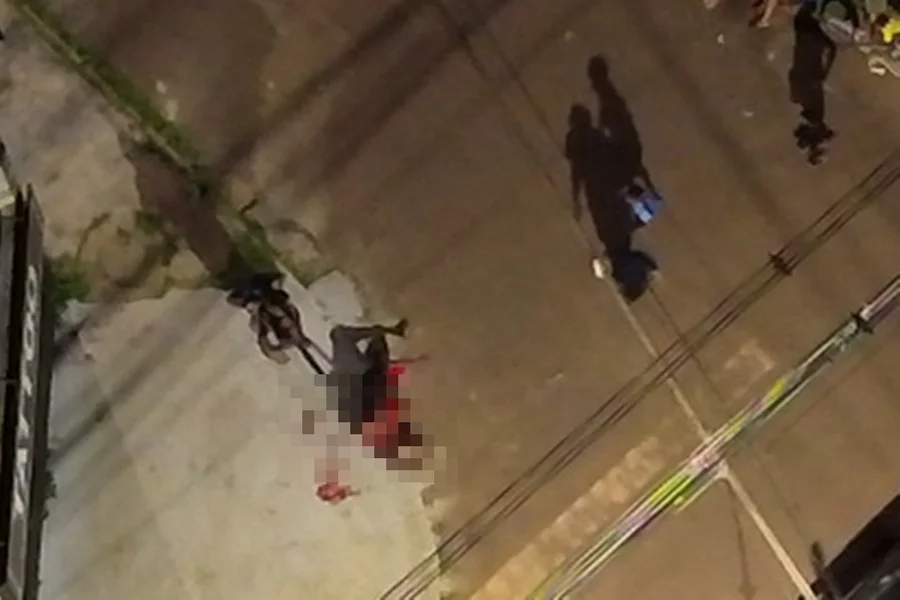 Homem sendo contido por populares e policiais em via pública no Distrito Federal