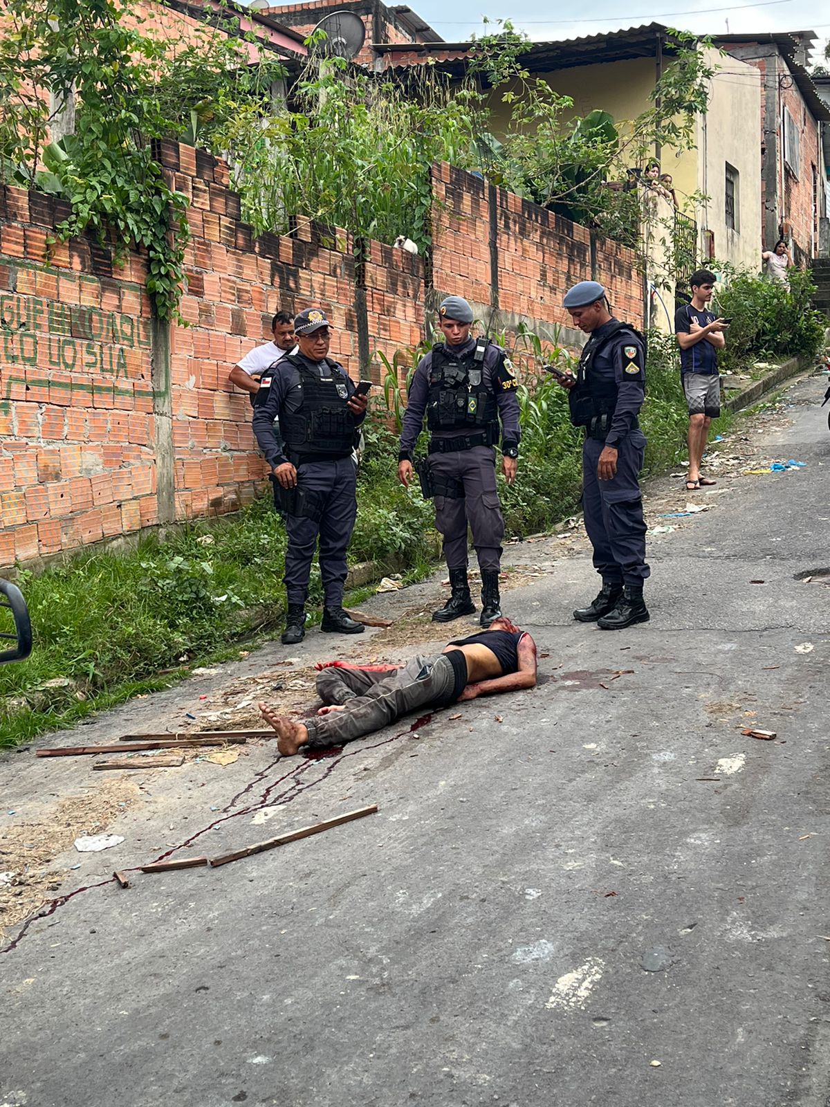 Viatura policial e aglomeração de pessoas no local de homicídio no bairro Jorge Teixeira em Manaus