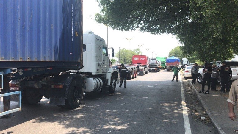 Agentes de trânsito realizando fiscalização de caminhões durante a operação Carga Pesada no Porto Chibatão em Manaus.
