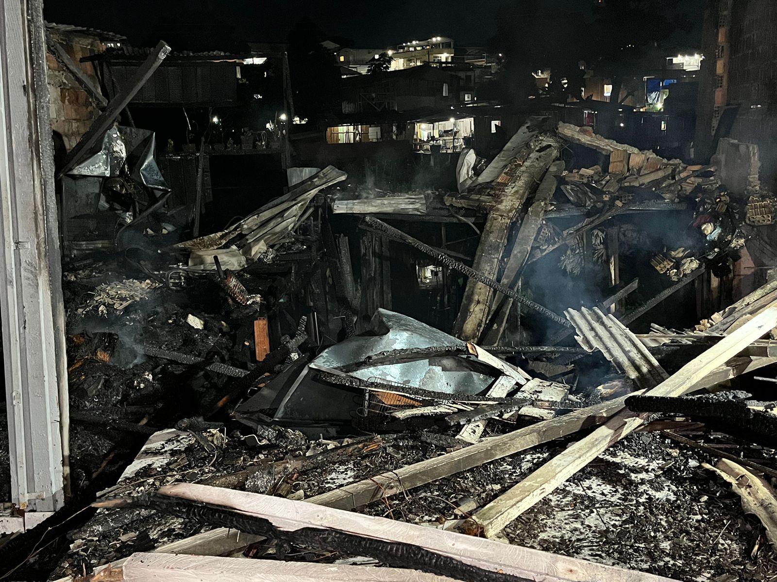Fumaça e chamas atingindo casas de madeira no bairro São Jorge em Manaus durante a noite