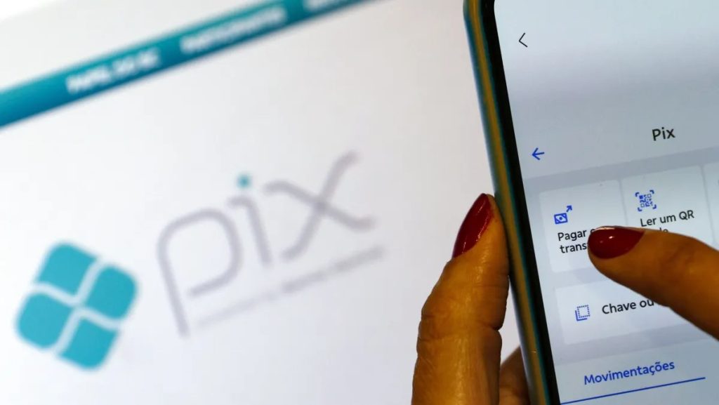 Pessoa utilizando celular para fazer pagamento via pix em um estabelecimento comercial