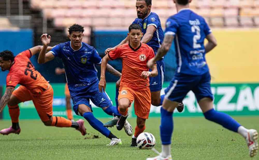 Jogadores de Manauara e Nacional em campo durante disputa de bola no estádio da Colina em Manaus.