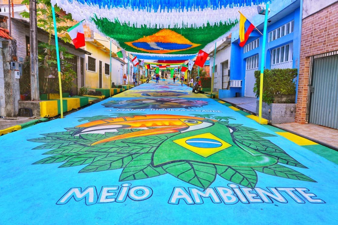 Vista de uma rua decorada para a Copa do Mundo com bandeiras e pinturas no asfalto em Manaus