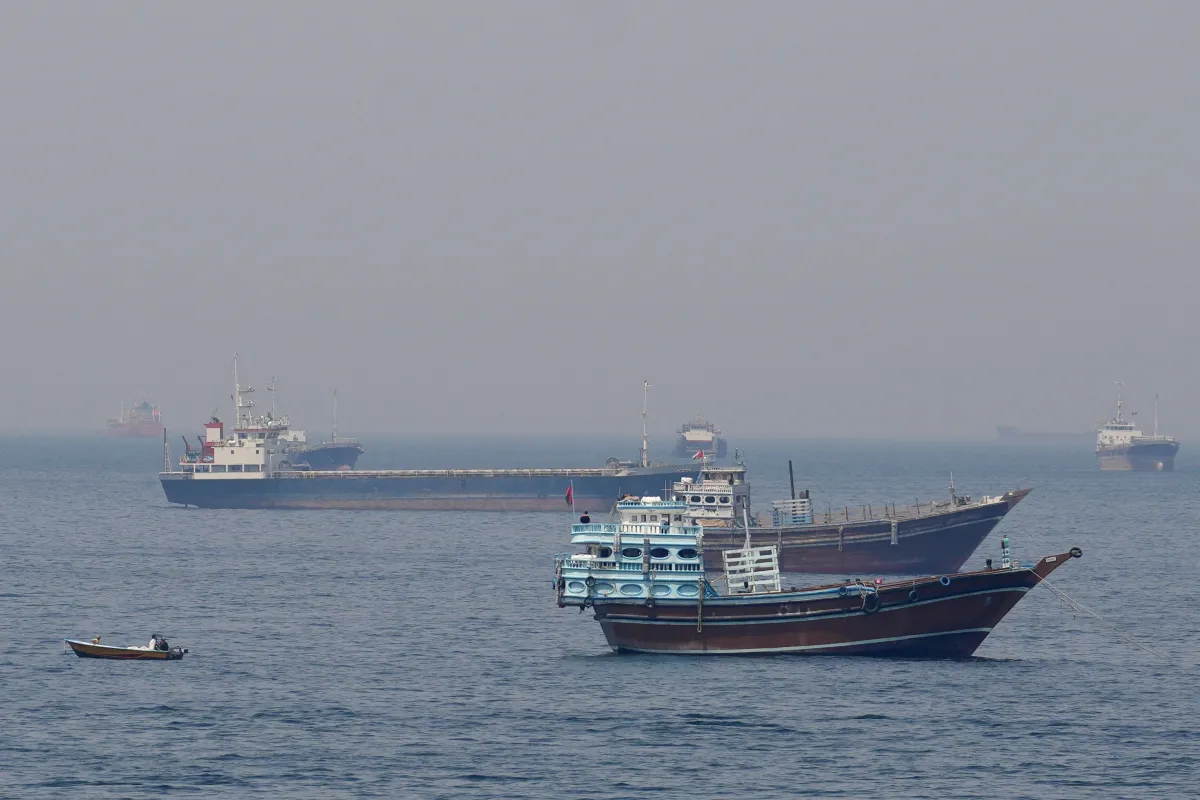 Vista de um grande navio cargueiro atravessando as águas do Estreito de Ormuz sob forte tensão diplomática.
